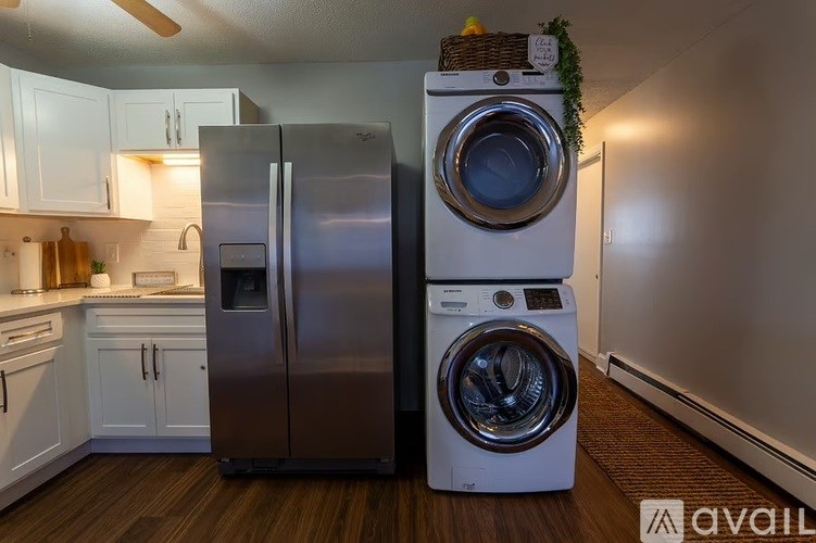 A white and silver refrigerator stands next to a white washing machine in a kitchen.