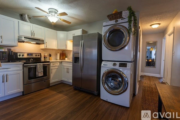 A kitchen with a white fridge and a fan on the ceiling.