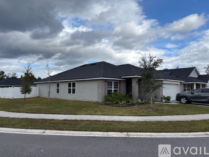 A house with a grey roof and a car parked in front.