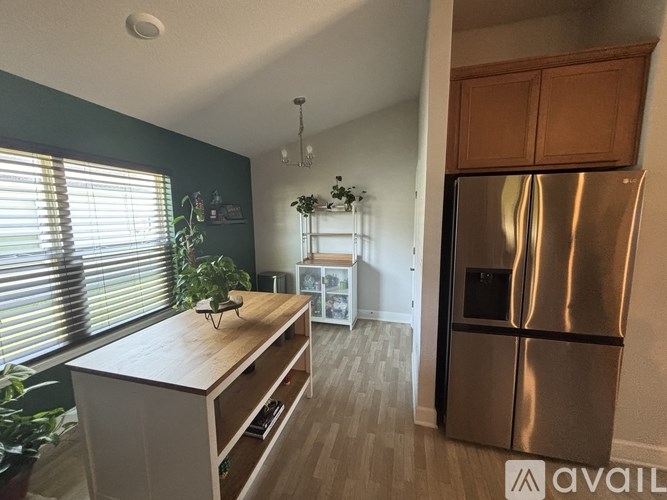 A kitchen with a stainless steel refrigerator and wooden countertops.