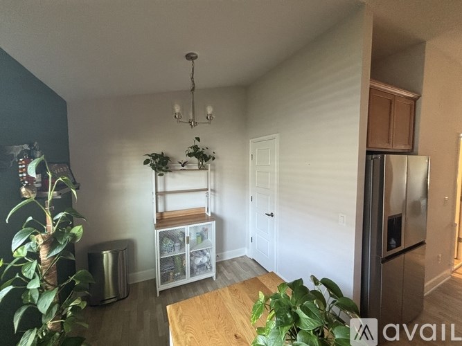 A kitchen with a wooden table and a refrigerator.