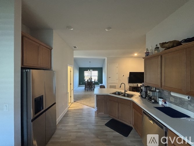A kitchen with wooden cabinets and a stainless steel refrigerator.