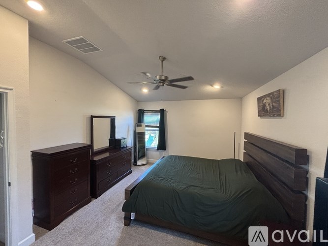 A bedroom with a bed, dresser, and mirror.