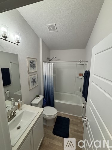 A bathroom with a toilet, sink, and bathtub.