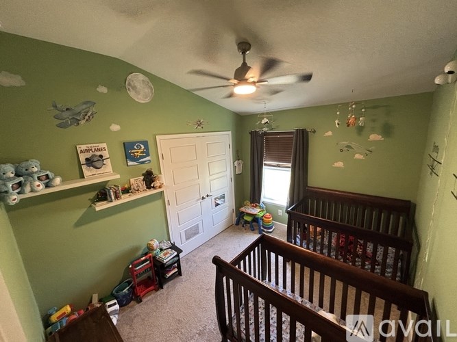 A baby room with a crib and a fan.