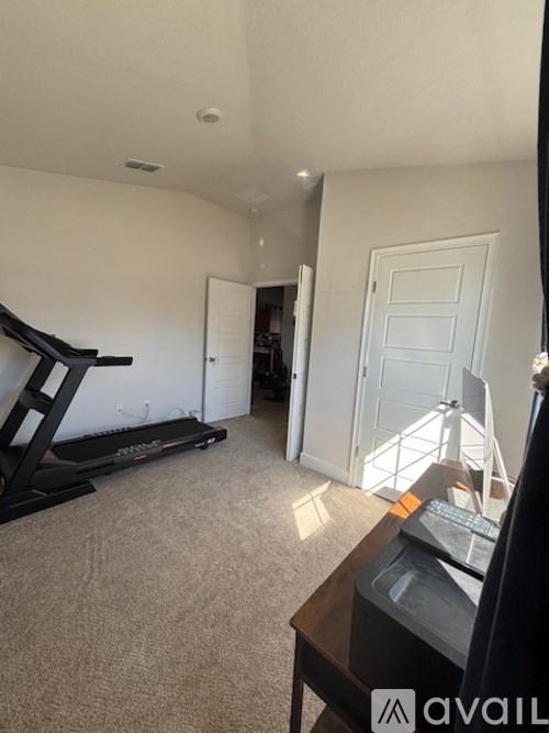 A room with a treadmill and a television.