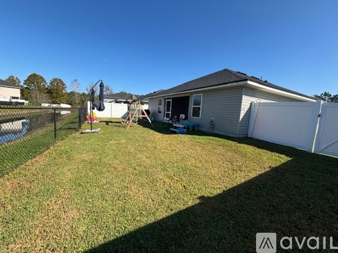 A backyard with a fence and a house in the background.
