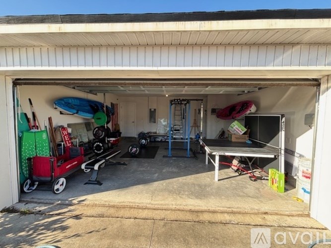 A garage with a table, chairs, and a red cart.