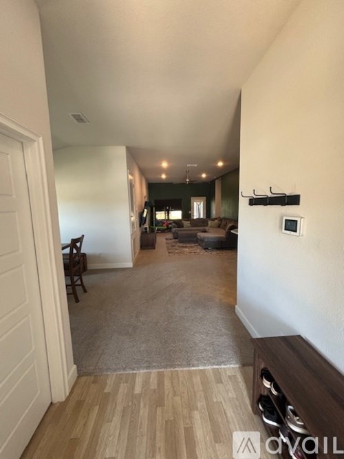 A hallway with a bench and a door on the left.
