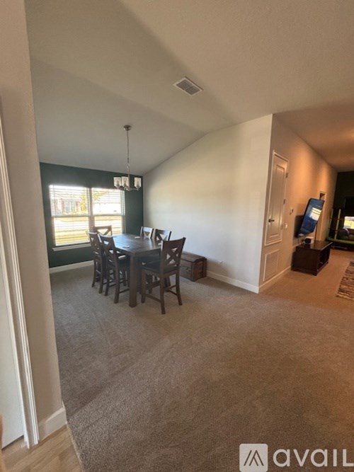 A dining room with a table and chairs.