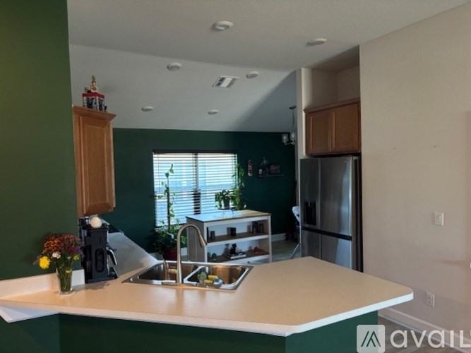 A kitchen with green walls and a white counter.