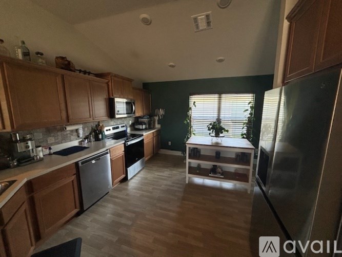 A kitchen with wooden cabinets and a black refrigerator.