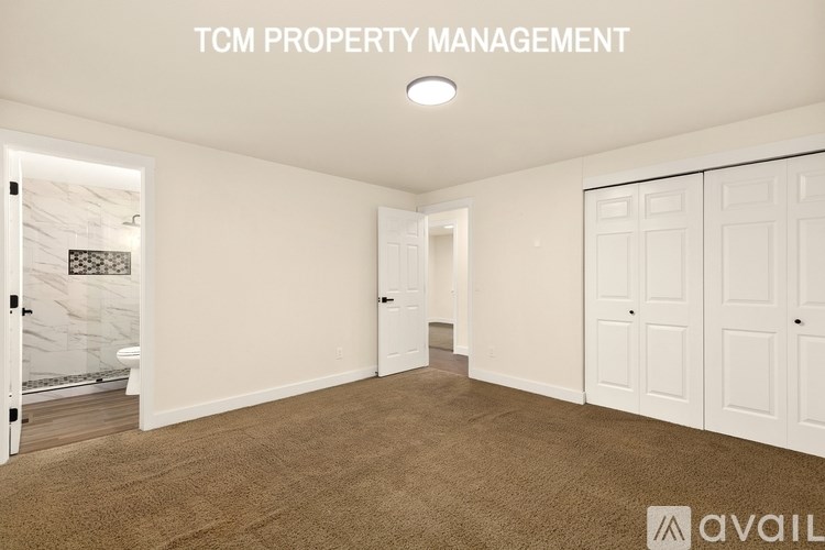 A room with white walls and a carpeted floor is available for rent.