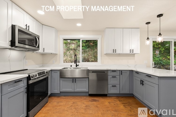A kitchen with a stove, microwave, and cabinets.
