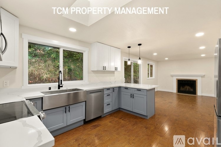 A kitchen with white cabinets and a wooden floor.