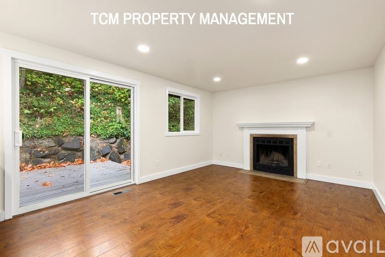 A room with a fireplace and a window overlooking a rocky landscape.