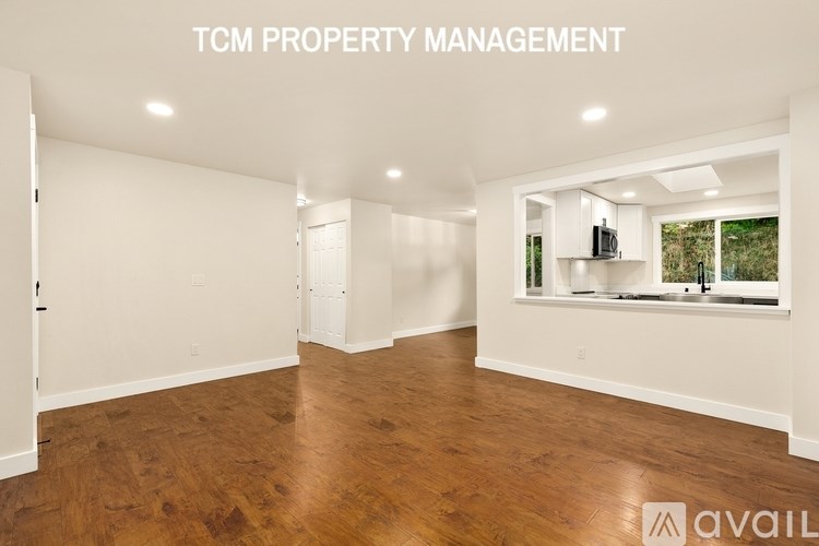 A spacious room with wooden flooring and white walls, managed by TCM Property Management.