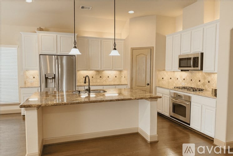 A kitchen with a granite countertop and stainless steel appliances.
