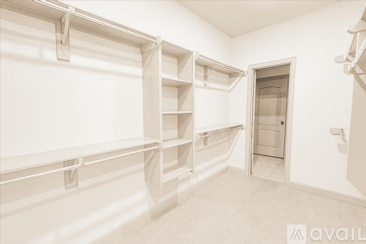 A white room with a door and shelves.