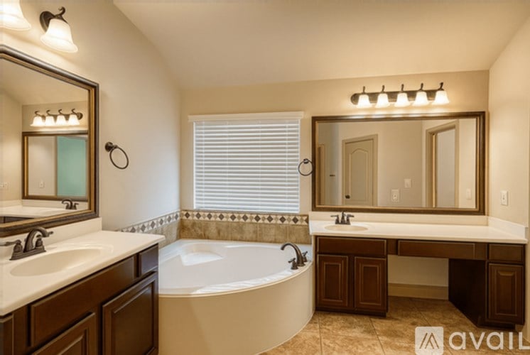 A bathroom with a tub, sink, and mirror.