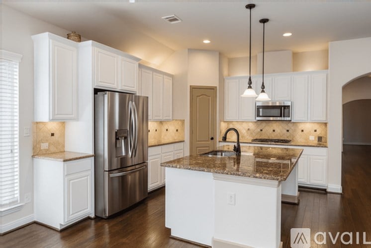 A kitchen with a granite countertop and stainless steel appliances.