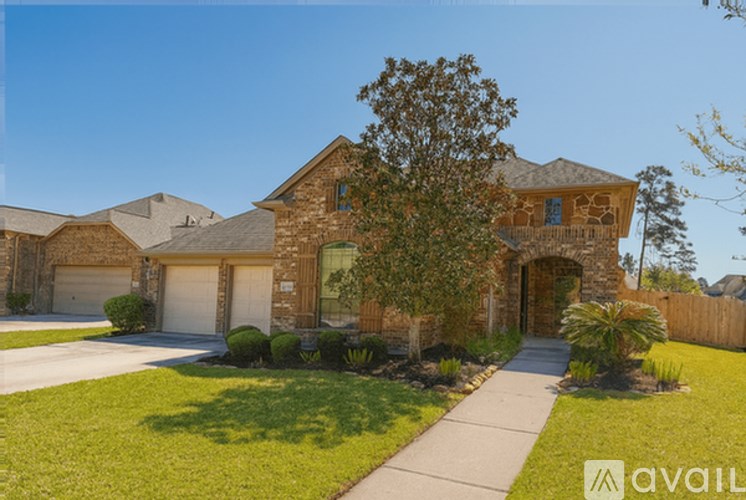 A house with a driveway and a tree in front.
