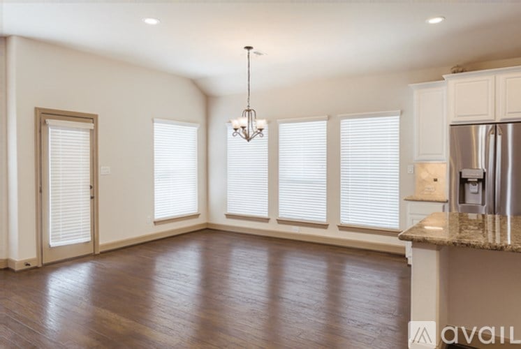 A kitchen with a granite countertop and a chandelier.
