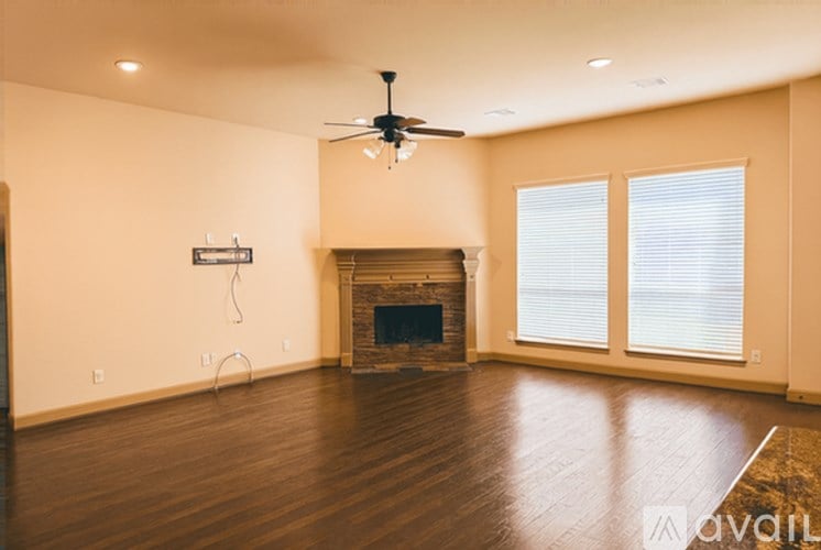 A living room with a fireplace and a fan.
