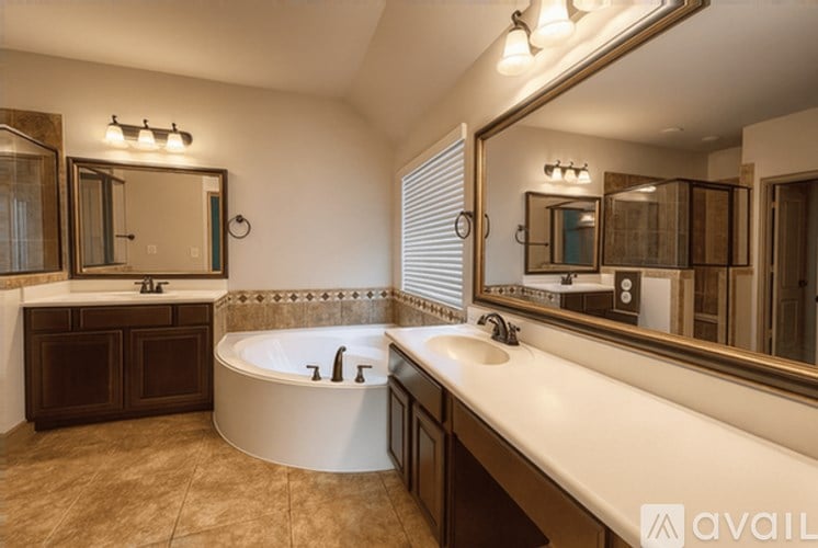 A bathroom with a tub, sink, and mirror.
