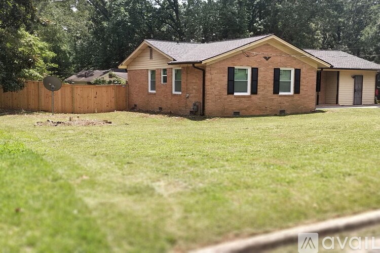 A house with a brown fence and a green lawn.