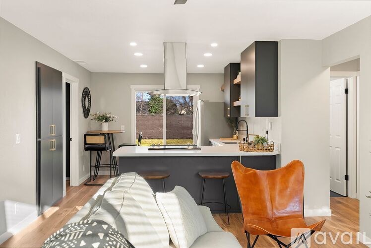 A modern kitchen with a large island and a view of the backyard.