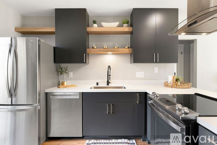 A modern kitchen with a refrigerator, sink, and stove.