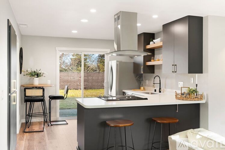 A modern kitchen with a large island and stools.