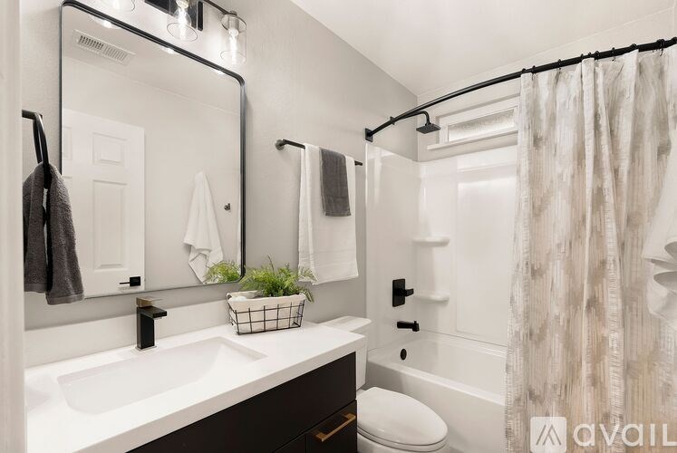A bathroom with a white sink and a white toilet.