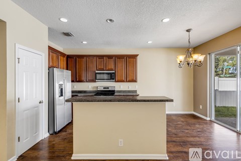 A kitchen with brown cabinets and a white refrigerator.