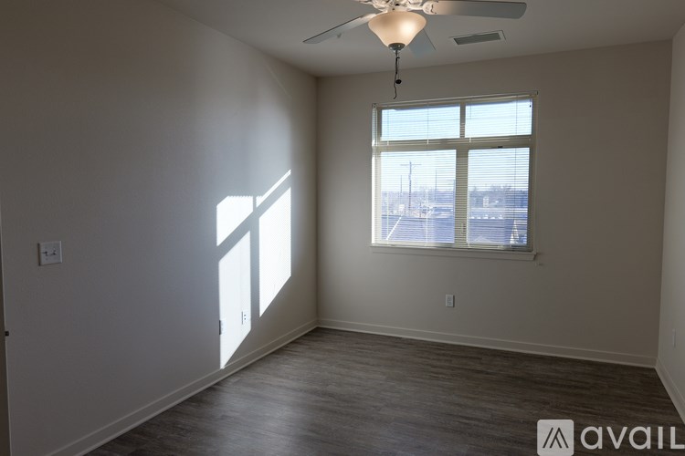 A room with a fan and a window overlooking a parking lot.