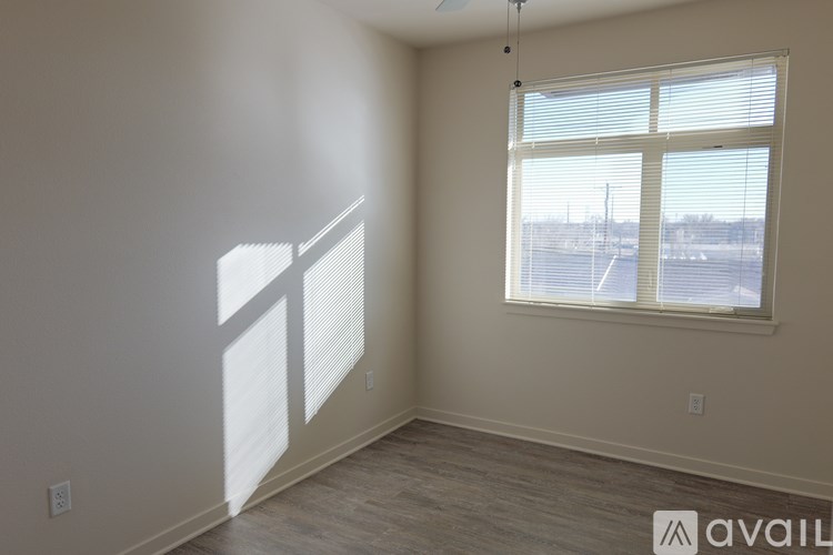 A room with a large window and a view of a parking lot outside.