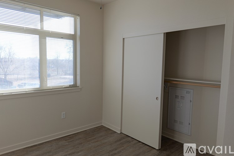 A room with a window and a door leading to a hallway.