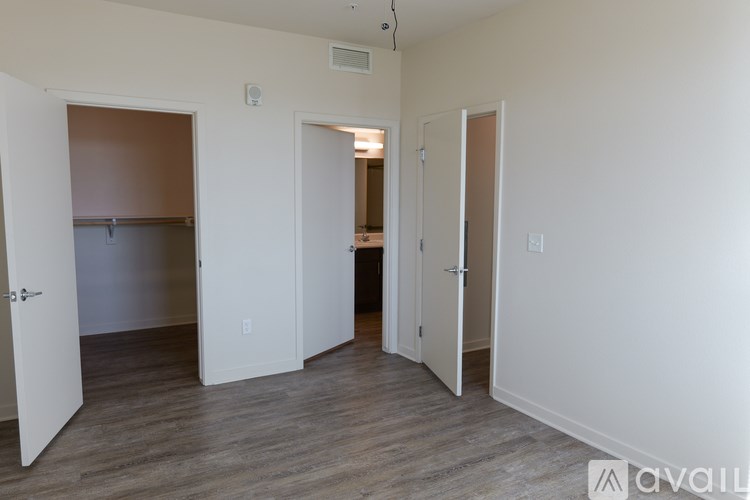 A room with three doors and a wooden floor.