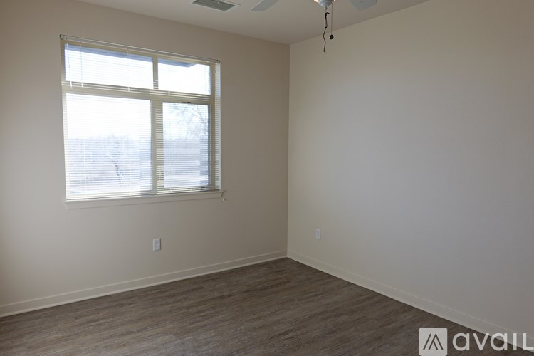A room with a window and wooden flooring is available for rent.