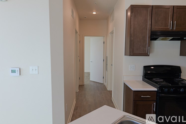 A kitchen with a black stove top oven and wooden cabinets.