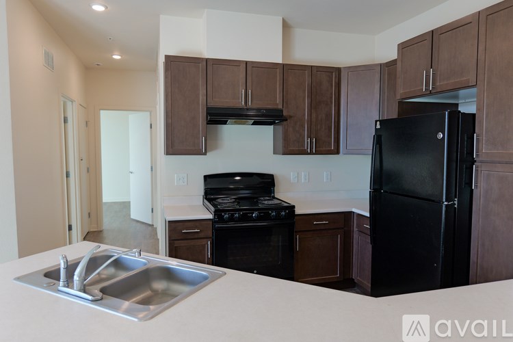 A kitchen with brown cabinets and black appliances.
