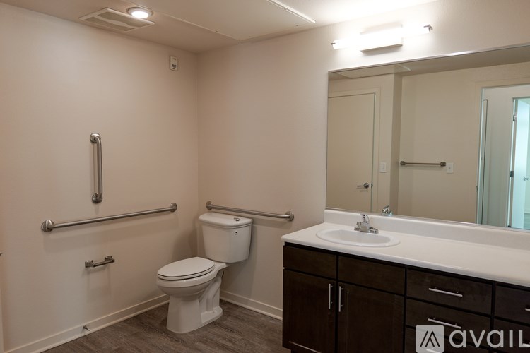 A bathroom with a toilet, sink, and mirror.