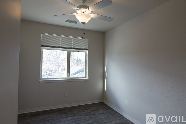 A room with a ceiling fan and a window with blinds.