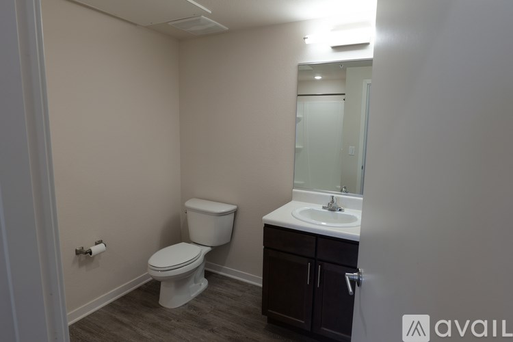 A bathroom with a toilet, sink, and cabinet.