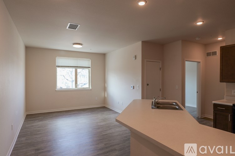A spacious room with a window, a door, and a countertop.