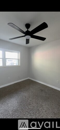 A room with a ceiling fan and a window.