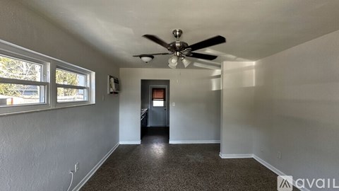 A room with a ceiling fan and a door.