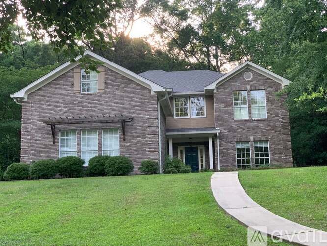 A house with a brick facade and a green lawn in front.