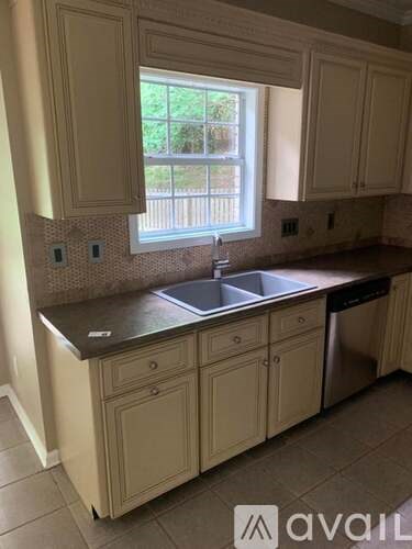 A kitchen with a window above the sink.
